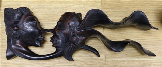 A Chinese hardwood carving of two heads, 34cm